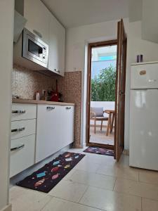 a kitchen with a refrigerator and a door leading to a patio at Vacation home Dora in Baška