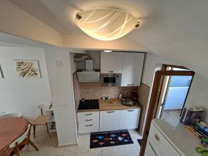 a small kitchen with a large light on the ceiling at Vacation home Dora in Baška