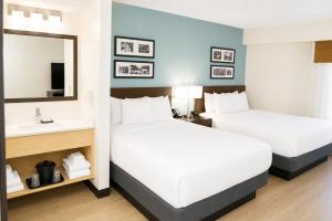 two beds in a hotel room with a mirror and a sink at Sleep Inn Staunton in Staunton +36 photos