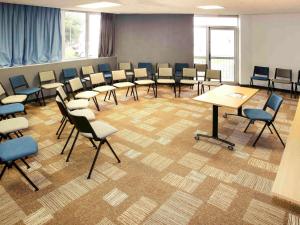 a room with tables and chairs in a classroom at ibis Poitiers Sud in Poitiers