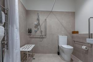 a bathroom with a shower and a toilet and a sink at The Stables Motel in Bulls