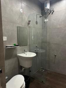 a bathroom with a toilet and a sink and a shower at King Residency in Chennai