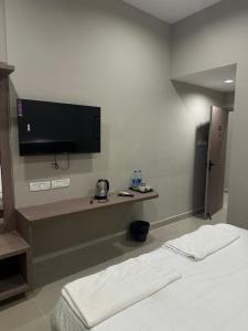 a hotel room with a bed and a flat screen tv at King Residency in Chennai