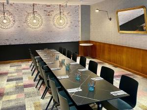 a conference room with a long table and chairs at ibis Saint-Omer Centre in Saint-Omer