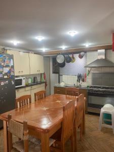 a kitchen with a wooden table and a refrigerator at Spacious Beach House with Pool for Relaxing in El Quisco