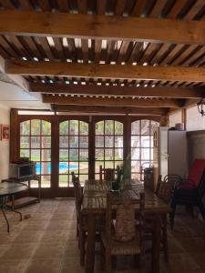 a dining room with a table and chairs and windows at Spacious Beach House with Pool for Relaxing in El Quisco