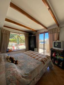 a bedroom with a bed with a teddy bear on it at Spacious Beach House with Pool for Relaxing in El Quisco