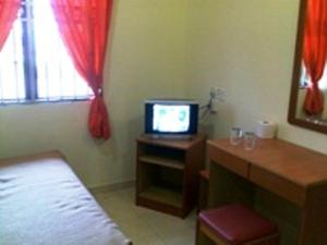 1 dormitorio con 1 cama y TV en una mesa en Sea Front Hotel Port Dickson, en Port Dickson