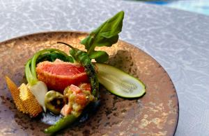 a plate of food with vegetables on a table at The ACONCAGUA RESORTS in Minami Aso