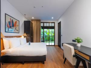 a bedroom with a bed and a desk and a desk at Kiara Beachtown Nusa Dua in Nusa Dua