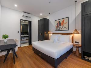 a bedroom with a bed and a desk and a piano at Kiara Beachtown Nusa Dua in Nusa Dua +33 photos