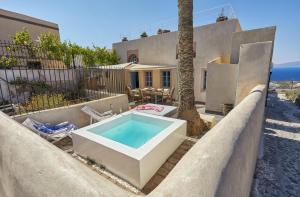 a house with a bath tub and a palm tree at 318 Oia Villa in Oia