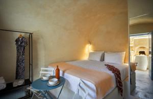 a bedroom with a large bed and a table at 318 Oia Villa in Oia +31 photos
