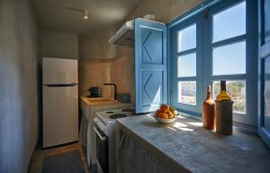 a kitchen with a counter with a bowl of fruit and a window at 318 Oia Villa in Oia