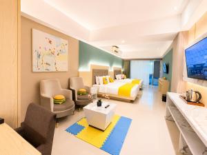 a bedroom with a bed and a living room at Luxury Malioboro Hotel in Yogyakarta