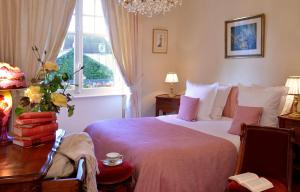 a bedroom with a bed and a table and a window at Hostellerie de la Motte jean in Saint-Coulomb