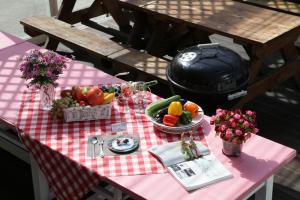 a pink picnic table with fruits and vegetables on it at Daecheon jeulgeoun pension in Boryeong