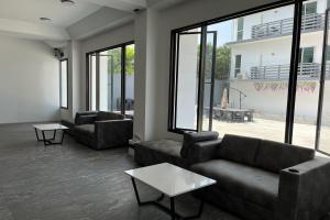 a living room with couches and tables and windows at VS Beach Front in Jomtien Beach