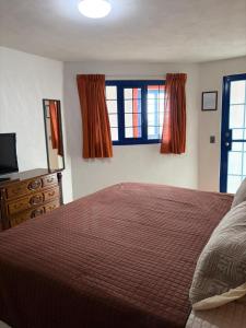 a bedroom with a bed and a tv and windows at Hotel Casa Don Marcos in Ixtafiayuca