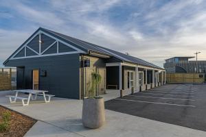 a building with a picnic table in a parking lot at The Stables Motel in Bulls