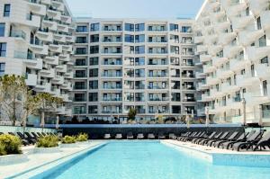 a swimming pool in front of a large apartment building at Beach Bliss std in Infinity Pool & Spa Resort in Năvodari