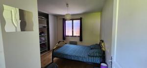 a small room with a bed and a window at La Résidence de Lorelei in Cierp