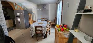 a kitchen with a table with chairs and a refrigerator at La Résidence de Lorelei in Cierp +37 photos