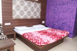a bedroom with a bed and a purple wall at Hotel Shoven in Dāvangere +20 photos