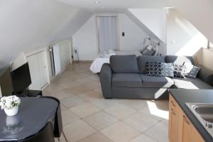 a living room with a couch and a bed at Au Grenier des Coccinelles in Pecq