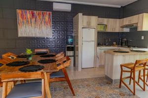 a kitchen with a wooden table and a refrigerator at Hotel Scarlette in Tulum
