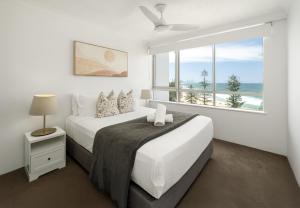 a white bedroom with a bed and a large window at Burleigh Beach Tower in Gold Coast +147 photos