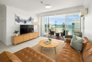 a living room with a couch and a television at Burleigh Beach Tower in Gold Coast