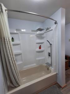 a white bathroom with a tub and a shower at Hunter's Haven in Haines