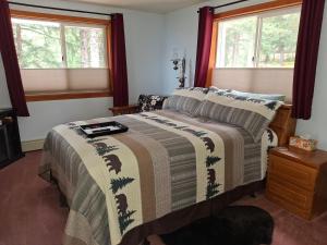 a bedroom with a bed and two windows at Hunter's Haven in Haines