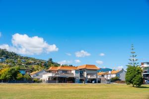 a group of houses in a yard with a green field at The Beachcomber Hotel in Nelson