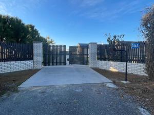a driveway in front of a fence with a gate at Self check-in studio with bathroom in Te Miro