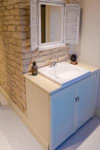 ein Badezimmer mit einem Waschbecken und einer Ziegelwand in der Unterkunft Jungbrunnen Orges in Orges