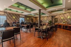 a restaurant with tables and chairs and people in the background at The Beachcomber Hotel in Nelson