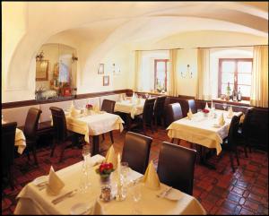 een eetkamer met tafels en stoelen met witte tafelkleden bij Landhotel Forsthof in Sierning
