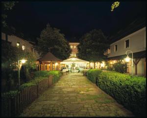 a cobblestone walkway leading to a house at night at Landhotel Forsthof in Sierning