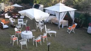 a group of tables and chairs under white umbrellas at Helianthus rooms in Pula