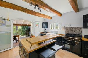 a kitchen with black cabinets and a wooden counter top at Provencal Villa With Pool In Collobrières in Contre
