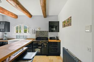 a kitchen with black appliances and a wooden counter at Provencal Villa With Pool In Collobrières in Contre
