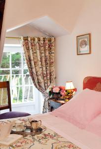 a bedroom with a bed and a table and a window at Hostellerie de la Motte jean in Saint-Coulomb