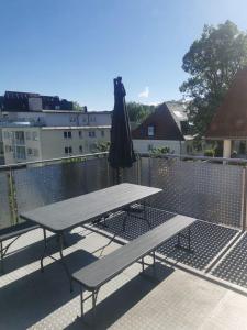 a picnic table and an umbrella on a balcony at Sleep & Stay in Kempten