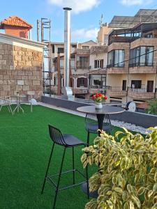 a patio with a table and chairs and green grass at Railway Studio 2 - Modern Studio in Byblos - Easy city Access in Jbeil