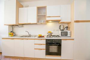 a kitchen with white cabinets and a microwave at Appartamento Centro Storico Riva 2 - Happy Rentals in Riva del Garda