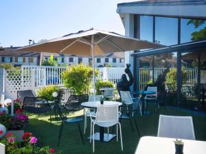 a patio with tables and chairs and an umbrella at ibis Cergy Pontoise Le Port in Cergy