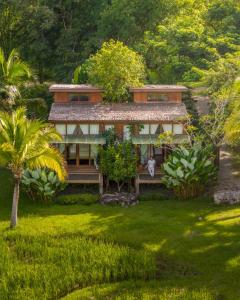 a house in the middle of a green yard at บ้านนาก๋างโต้ง Baan Na Kang Tong in Ban Kot