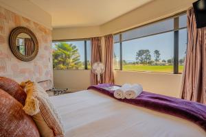a bedroom with a bed with two rolled towels at The Beachcomber Hotel in Nelson +84 photos